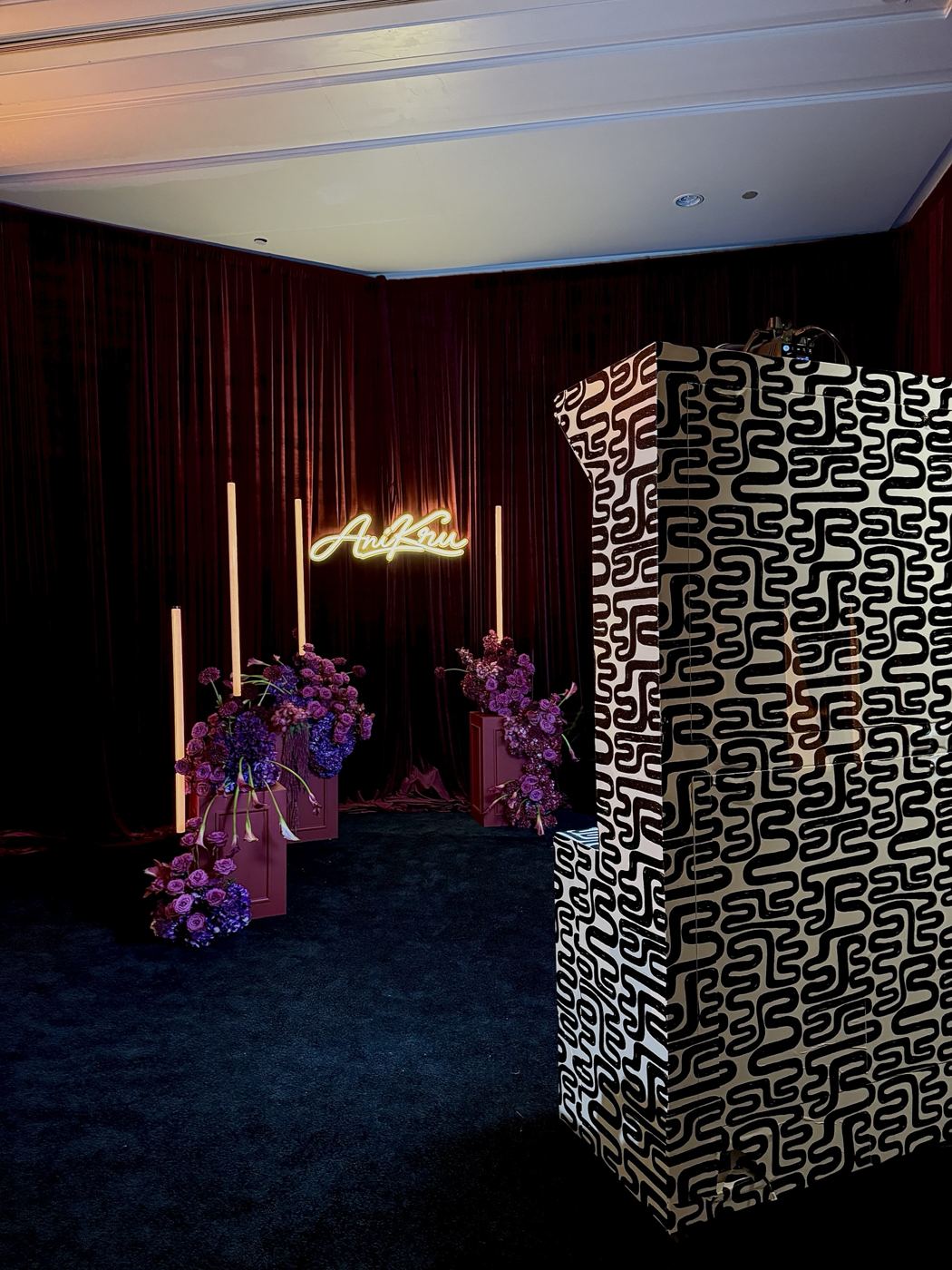 Mochi Booth in a custom black-and-white wrap beside a velvet-draped photo set with purple florals, glowing light columns and an AniKru neon sign at The Ritz-Carlton, Laguna Niguel